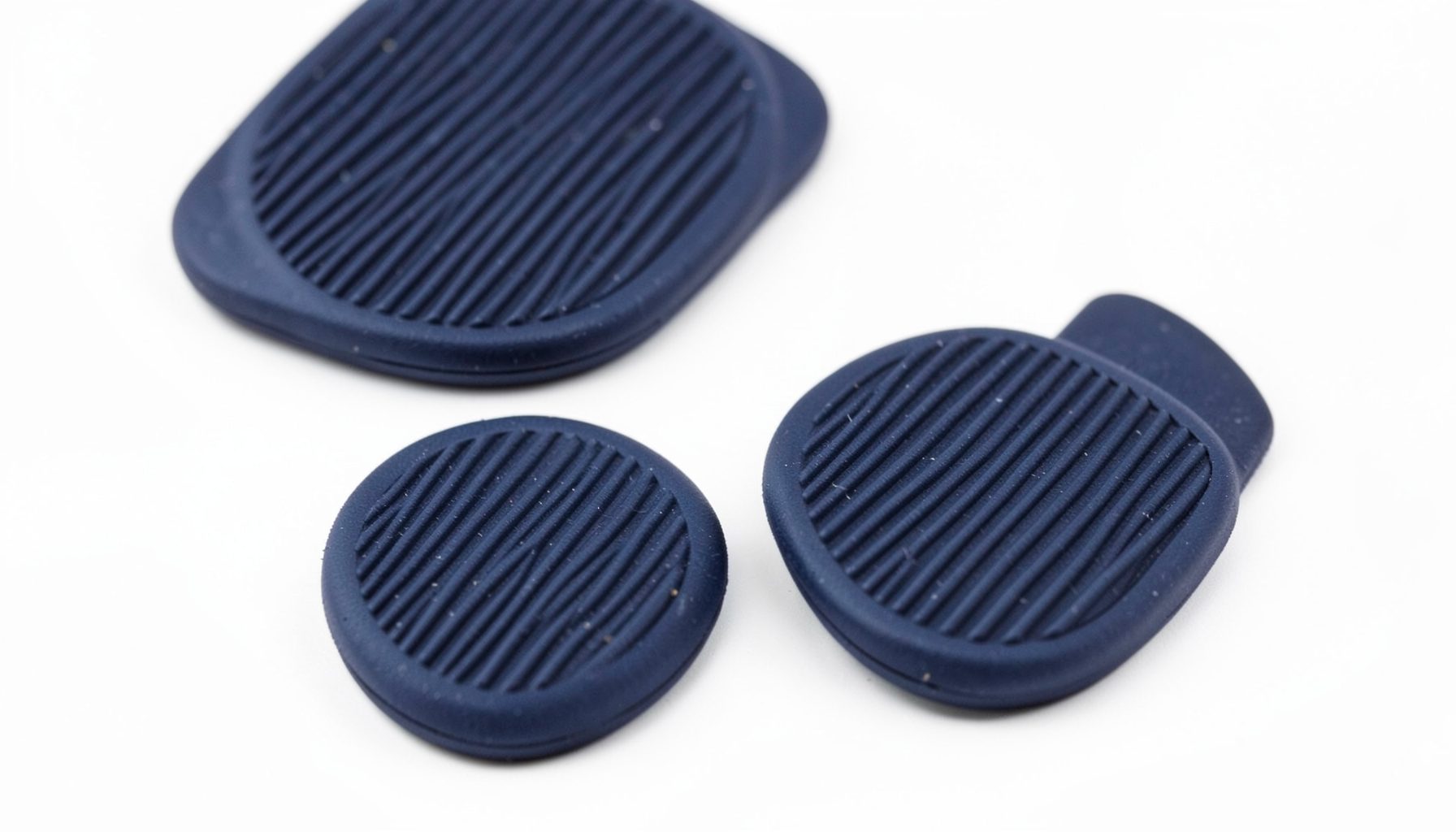 Close-up of dark navy rounded rubber heel pads with ridged texture on white background