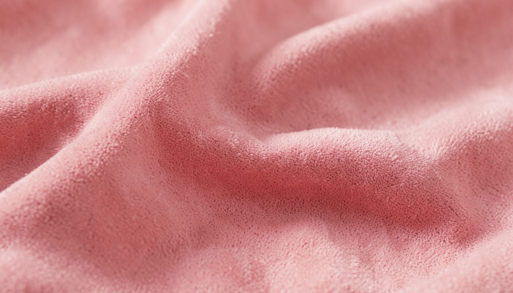 Close-up of soft pink suede-like fabric with gentle folds, warm and calm mood