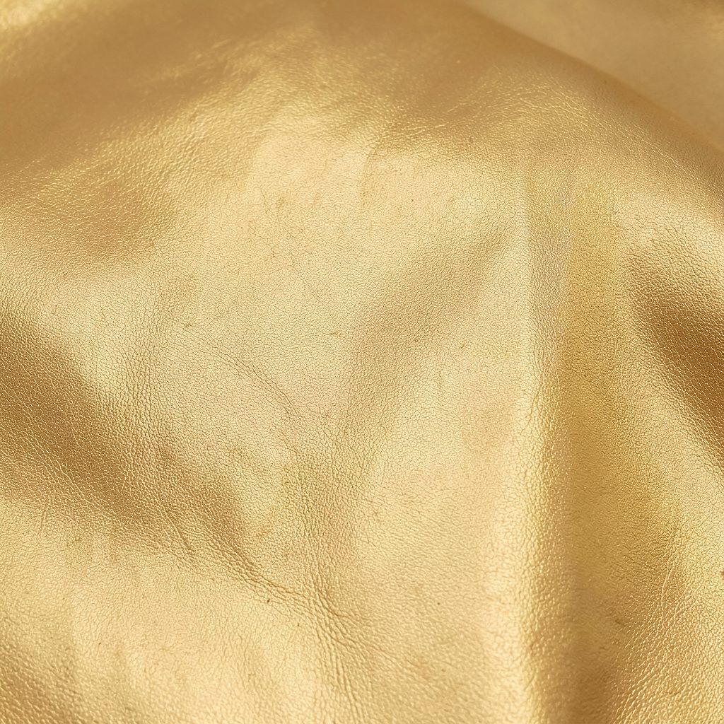 Warm metallic gold-toned soft leather texture with a subtle sheen, reflecting the Ribbon Flexi Gold finish