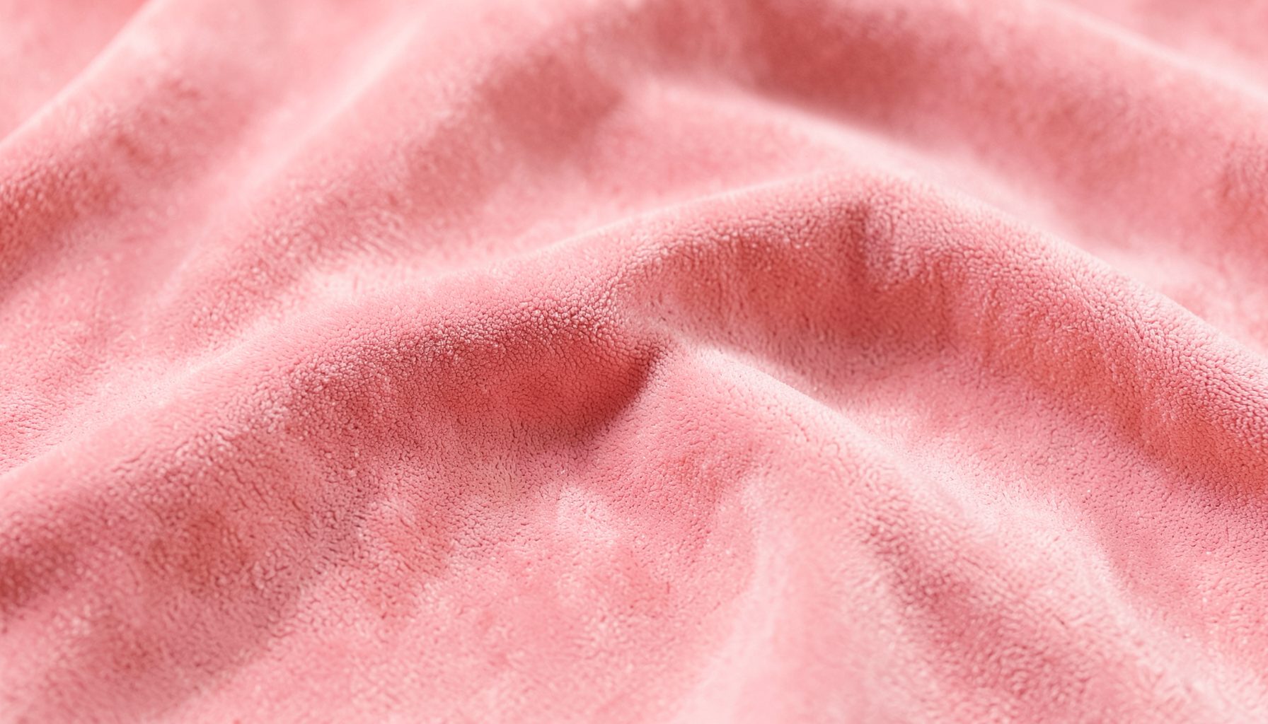 Soft pink suede-like fabric texture with gentle folds, warm and inviting mood